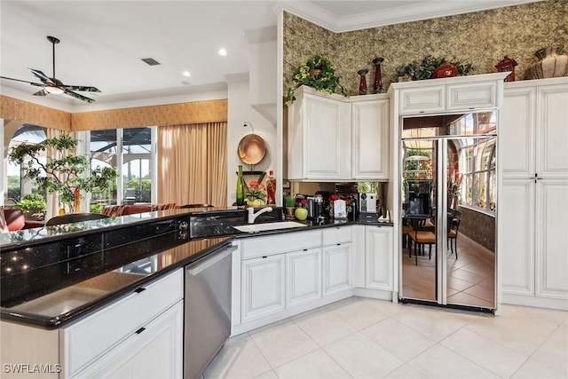 kitchen featuring dark stone countertops, stainless steel dishwasher, kitchen peninsula, built in fridge, and white cabinets