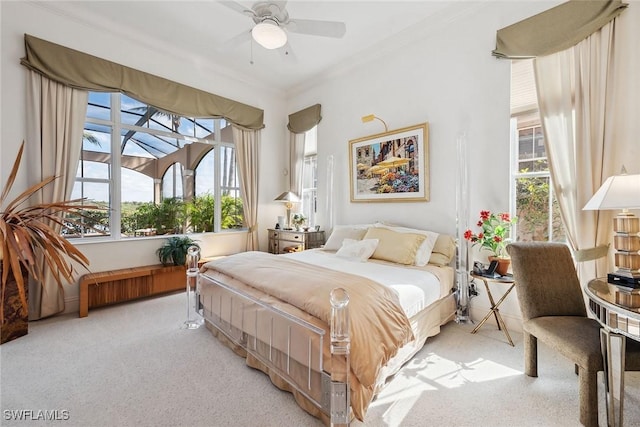 carpeted bedroom featuring crown molding and ceiling fan