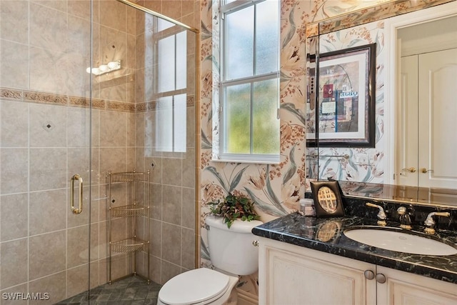 bathroom featuring an enclosed shower, vanity, and toilet