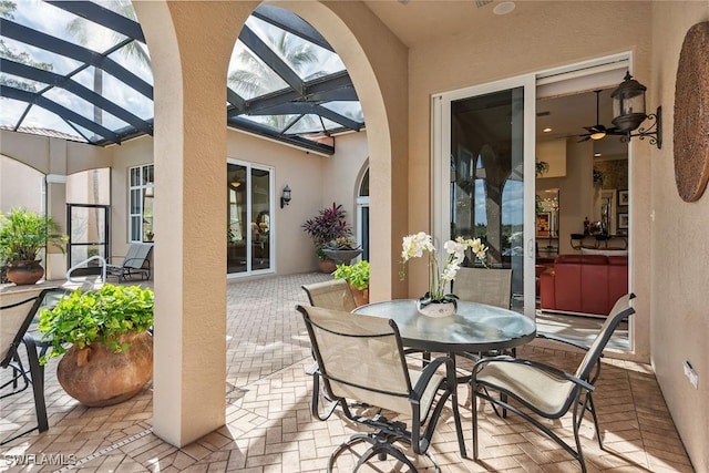 view of patio / terrace with ceiling fan and glass enclosure