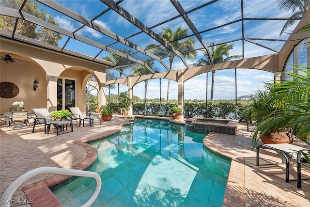 view of swimming pool featuring an in ground hot tub, ceiling fan, a lanai, and a patio