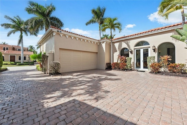 mediterranean / spanish-style home with french doors and a garage