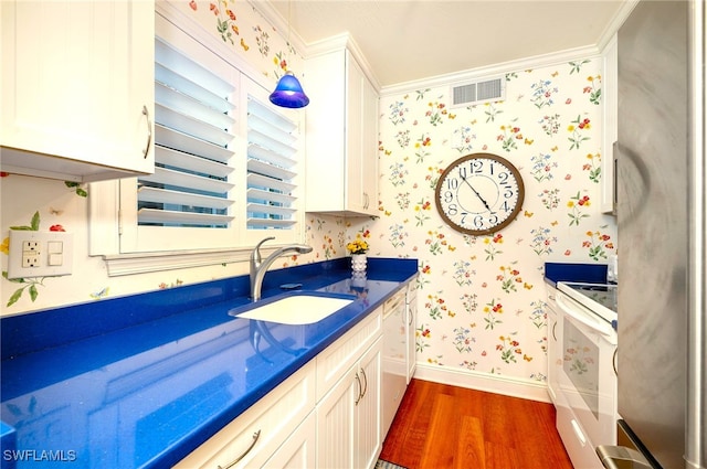 interior space with hardwood / wood-style flooring, crown molding, and sink