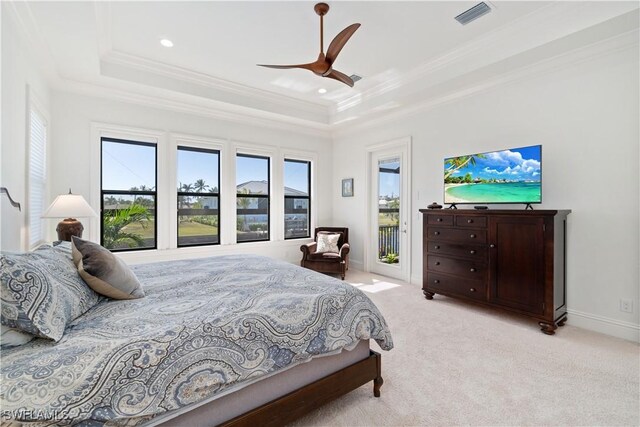 carpeted bedroom featuring ornamental molding, access to exterior, a raised ceiling, and multiple windows