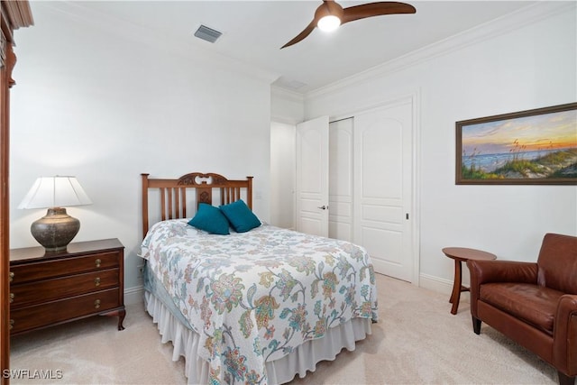 bedroom featuring ceiling fan, light colored carpet, ornamental molding, and a closet