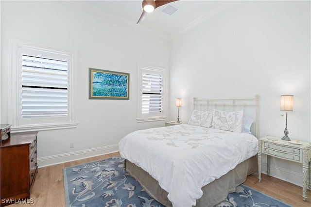 bedroom with ceiling fan, ornamental molding, and wood-type flooring