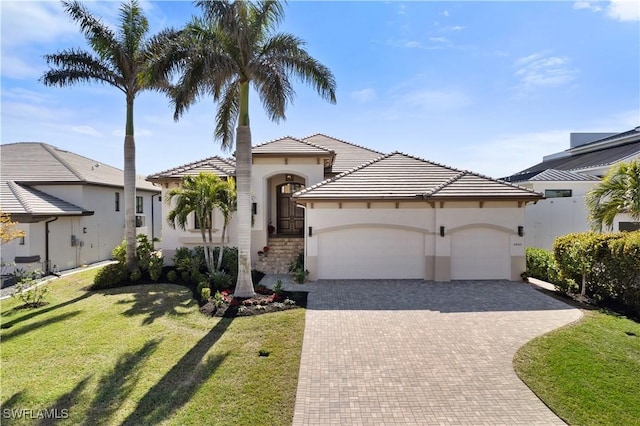 mediterranean / spanish house featuring a garage and a front lawn