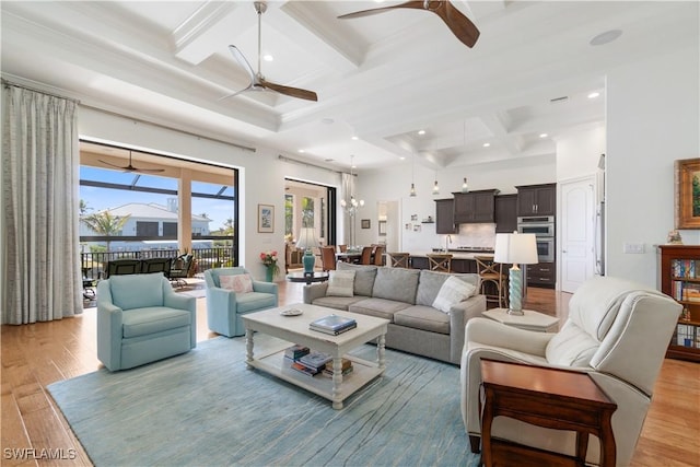 living room with coffered ceiling, ceiling fan with notable chandelier, beam ceiling, and light wood-type flooring