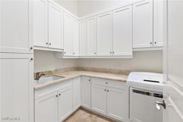 laundry room with heating unit, sink, and cabinets