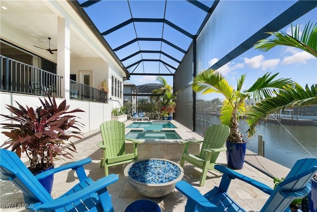 view of patio with a water view, a lanai, ceiling fan, and a pool with hot tub