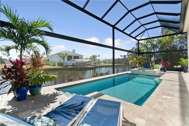 view of pool with an in ground hot tub, a water view, a patio area, and glass enclosure