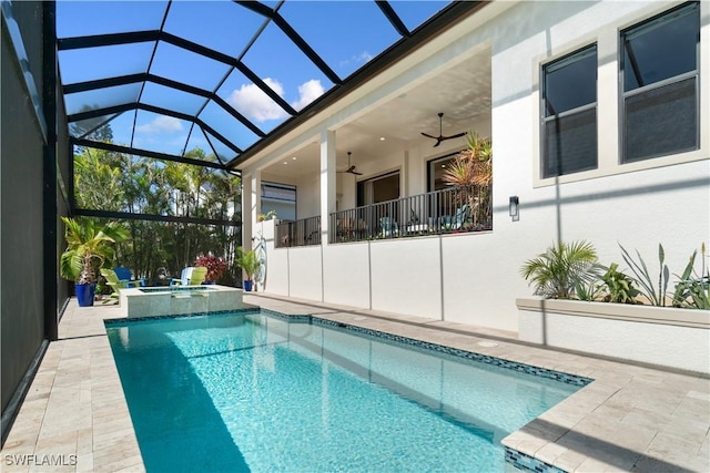 view of pool with an in ground hot tub, ceiling fan, glass enclosure, and a patio area