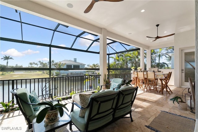 sunroom / solarium with a water view and ceiling fan