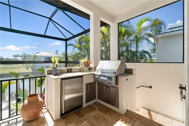 view of patio with a water view, an outdoor kitchen, grilling area, and a lanai