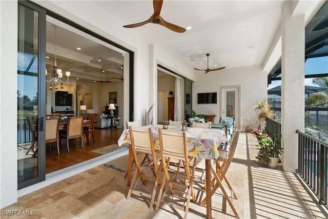 sunroom with ceiling fan with notable chandelier