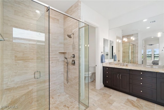 bathroom with vanity, a shower with shower door, and toilet