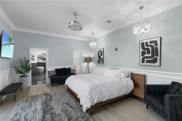 bedroom with an inviting chandelier, crown molding, and light wood-type flooring