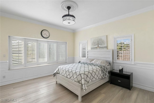 bedroom with crown molding and light hardwood / wood-style floors