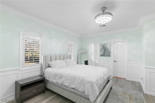 bedroom featuring crown molding and light wood-type flooring