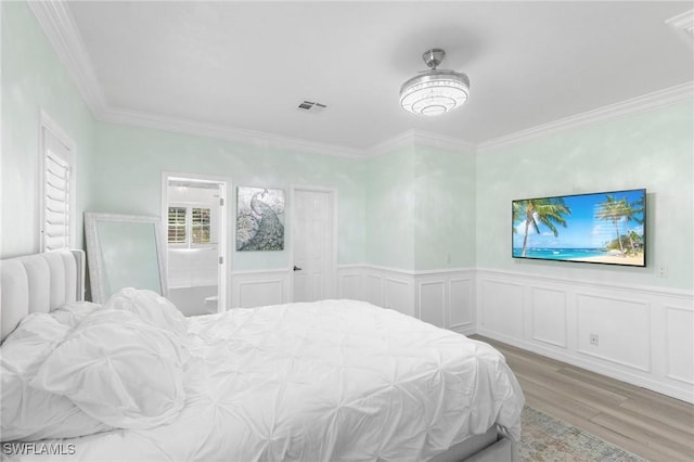 bedroom featuring connected bathroom, crown molding, and light hardwood / wood-style floors