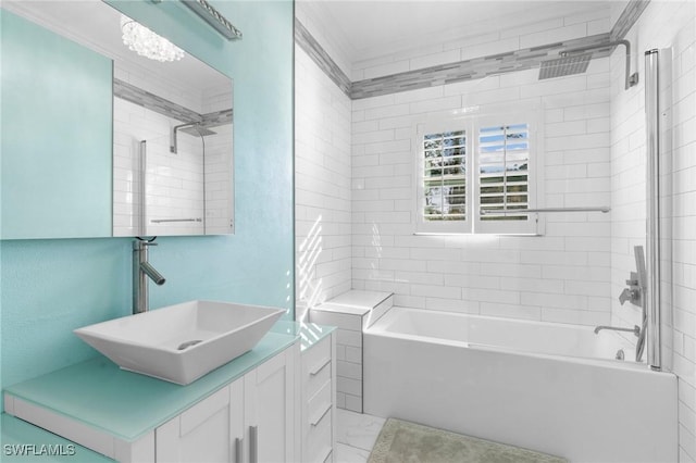 bathroom with crown molding, vanity, and tiled shower / bath combo