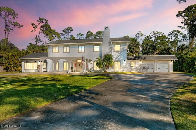 view of front of home with a garage and a lawn