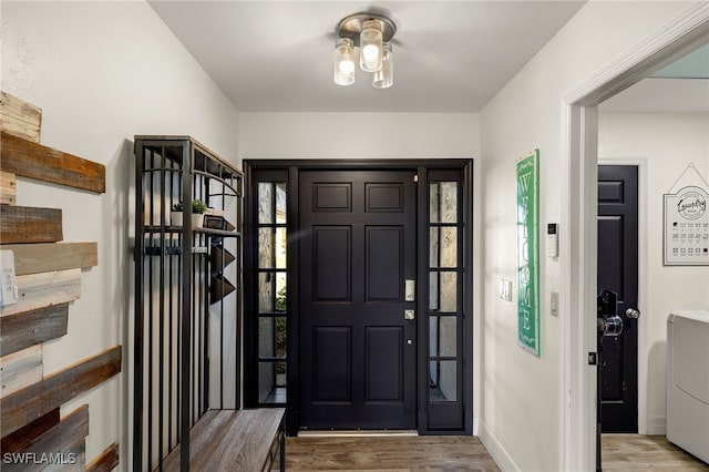 foyer entrance with wood-type flooring and washer / dryer