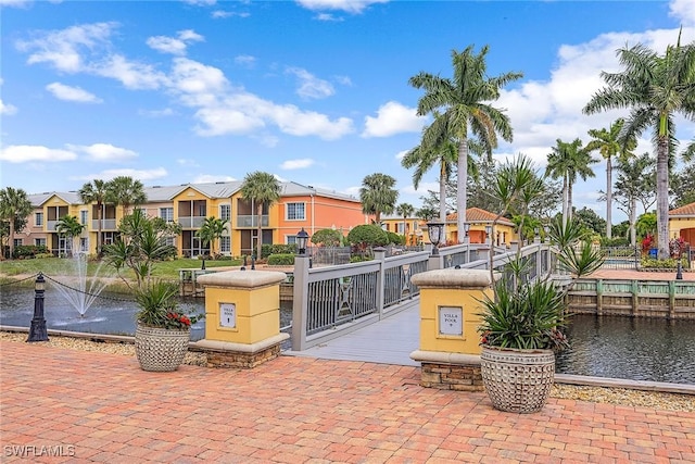view of property's community with a water view, a residential view, and fence