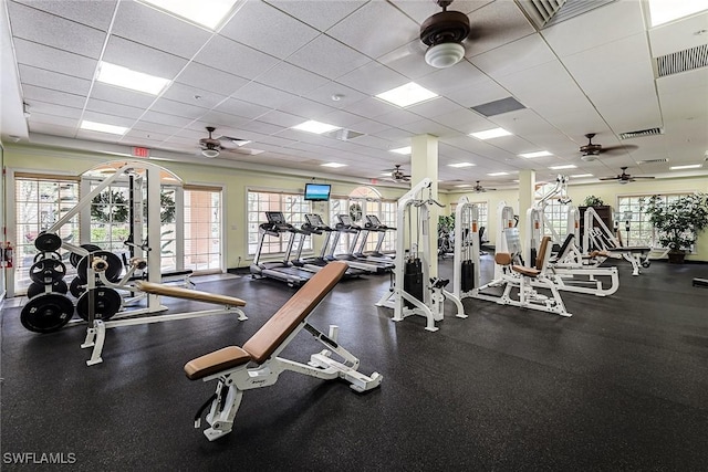 workout area featuring ceiling fan and a drop ceiling