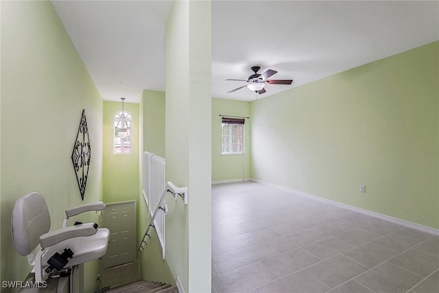 spare room with healthy amount of natural light, a ceiling fan, and baseboards