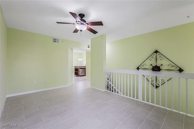 spare room featuring ceiling fan, baseboards, and tile patterned flooring