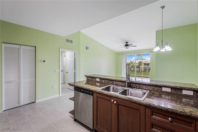 kitchen featuring vaulted ceiling, dishwasher, sink, dark stone counters, and hanging light fixtures