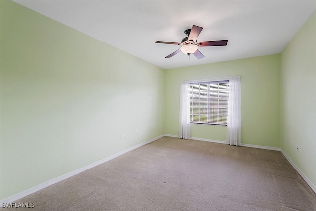 spare room featuring carpet, ceiling fan, and baseboards