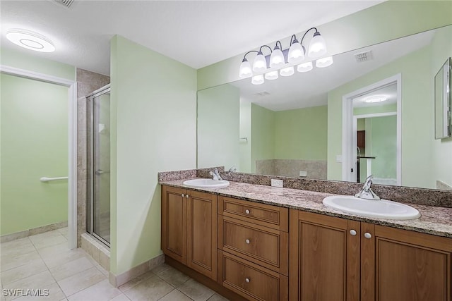 bathroom with tile patterned flooring, a shower stall, double vanity, and baseboards