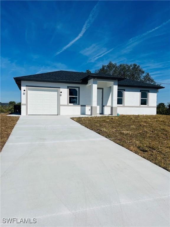 view of front of property with a garage and a front lawn