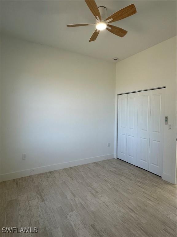 unfurnished bedroom with light hardwood / wood-style flooring, a closet, and ceiling fan