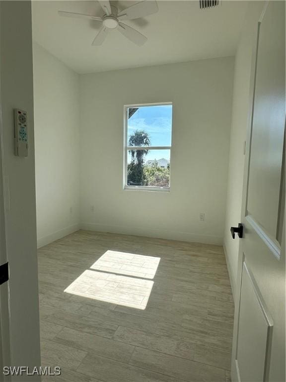 spare room featuring light hardwood / wood-style flooring and ceiling fan