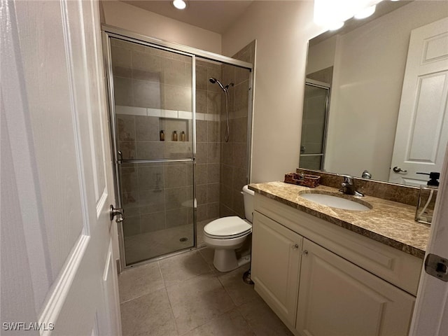 bathroom with vanity, tile patterned floors, toilet, and walk in shower