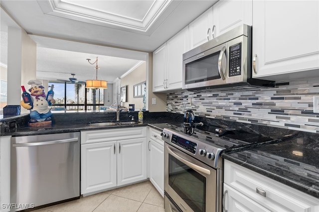 kitchen featuring appliances with stainless steel finishes, sink, white cabinets, and dark stone counters