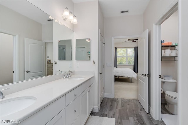 bathroom with vanity, ceiling fan, hardwood / wood-style flooring, and toilet