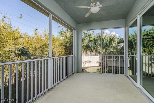 unfurnished sunroom with ceiling fan