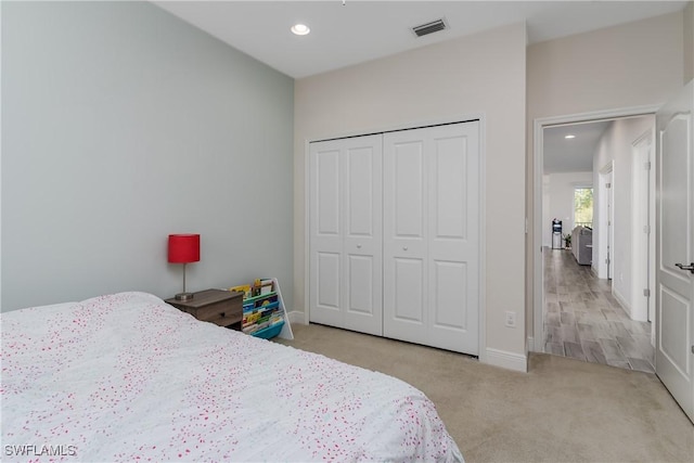 bedroom featuring light colored carpet and a closet