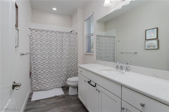 bathroom featuring vanity, hardwood / wood-style flooring, toilet, and walk in shower