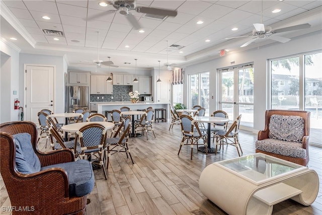 dining space featuring crown molding, a healthy amount of sunlight, and a tray ceiling