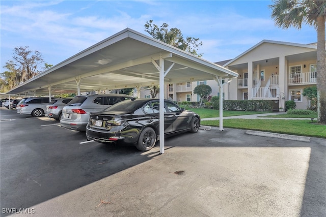 view of parking / parking lot featuring a carport and a lawn