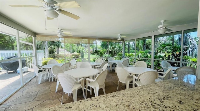 sunroom featuring ceiling fan