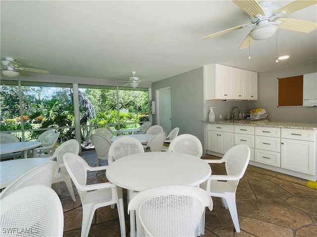 dining room with ceiling fan and sink