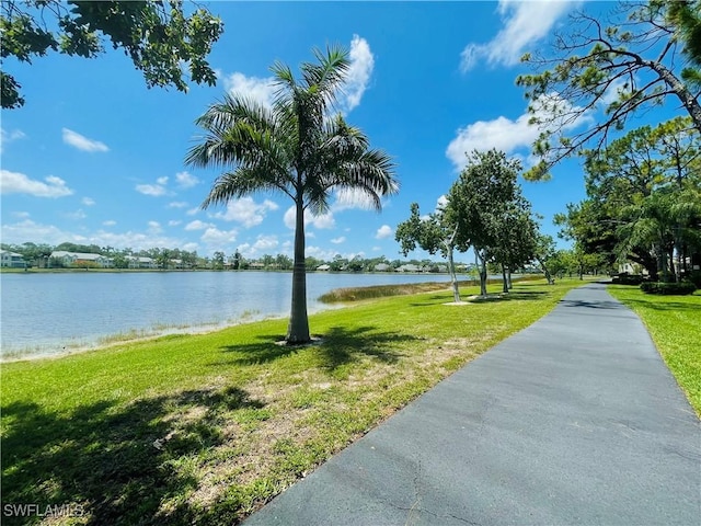 surrounding community featuring a water view and a lawn