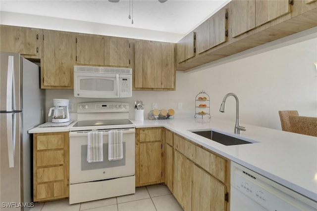 kitchen featuring sink, light brown cabinetry, and white appliances