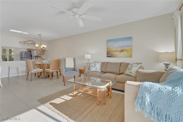 tiled living room with ceiling fan with notable chandelier